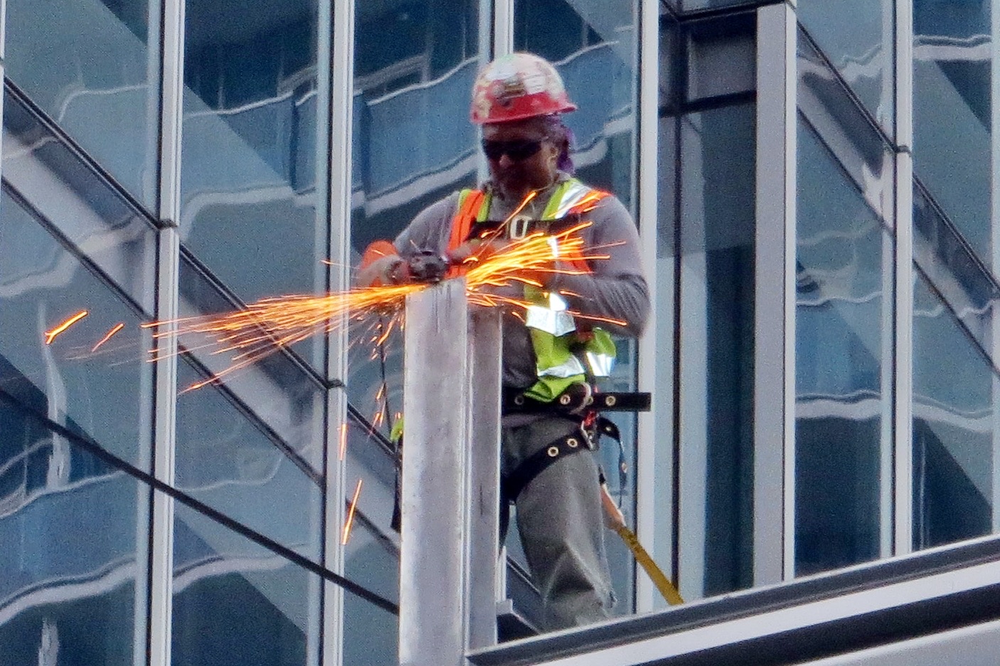 A construction worker cutting steel on a building site, sparks flying