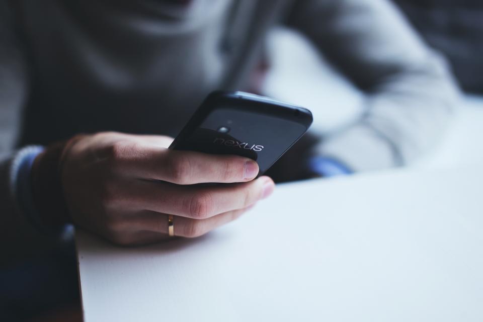 Close-up of hands typing a message on a smartphone